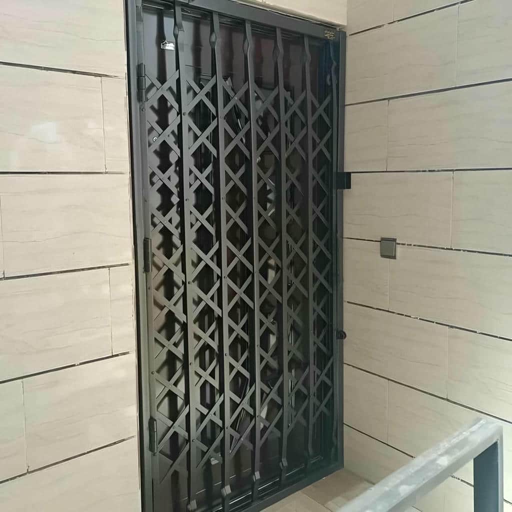 نصب درب آکاردئونی مشکی کنار ورودی شیشه‌ای