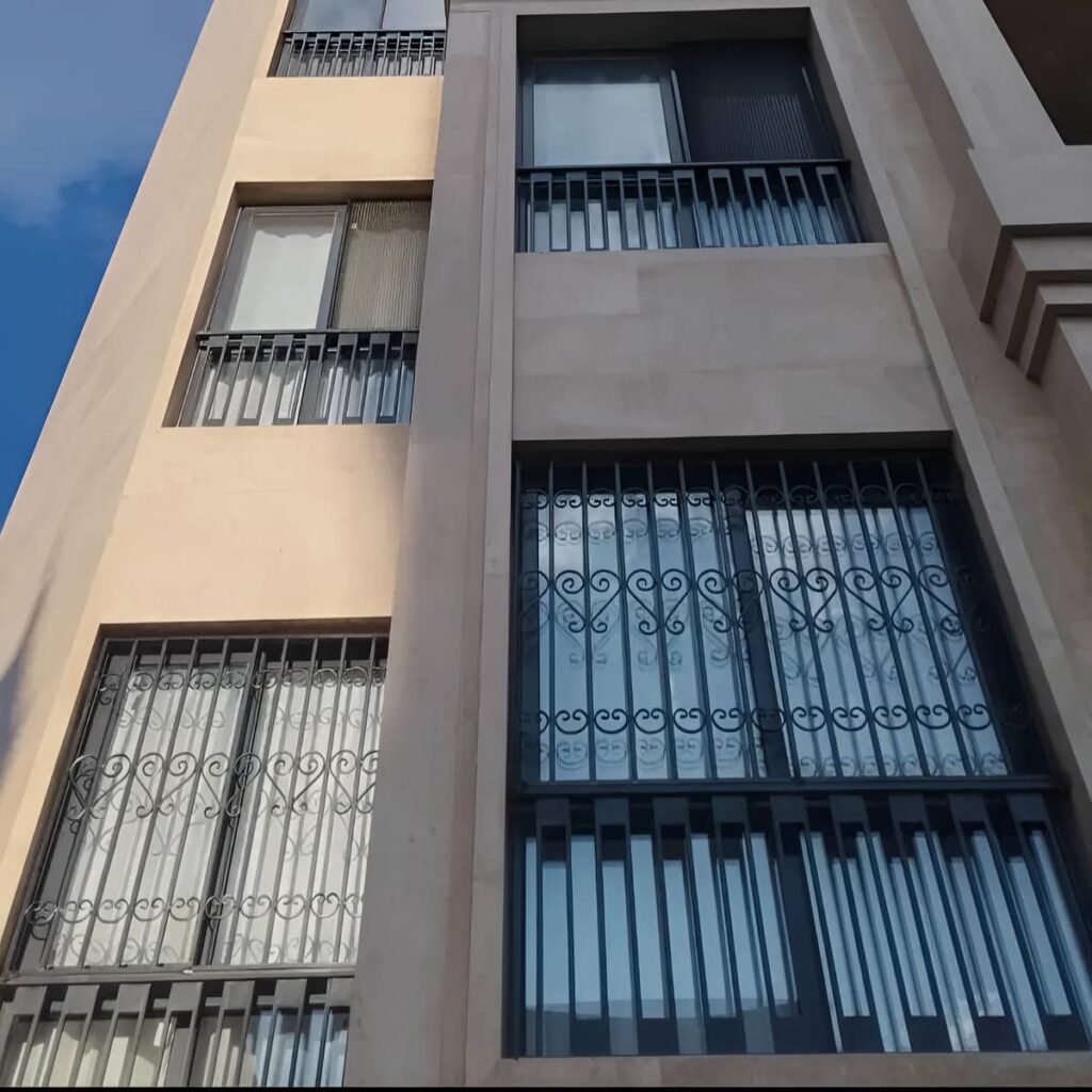 اجرای حفاظ پنجره پروفیلی روی نمای سنگی ساختمان